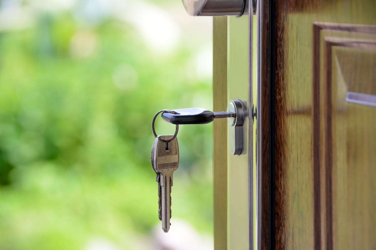Key inserted in door lock against a blurred green background, symbolizing security and real estate. Σπίτι
